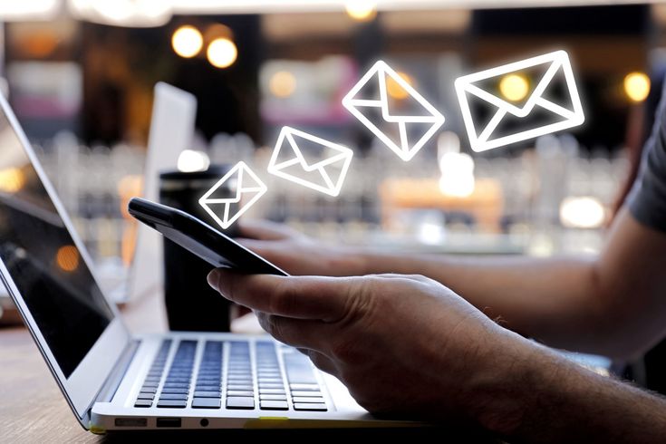 Marketing professional designing email campaign strategy with laptop and charts