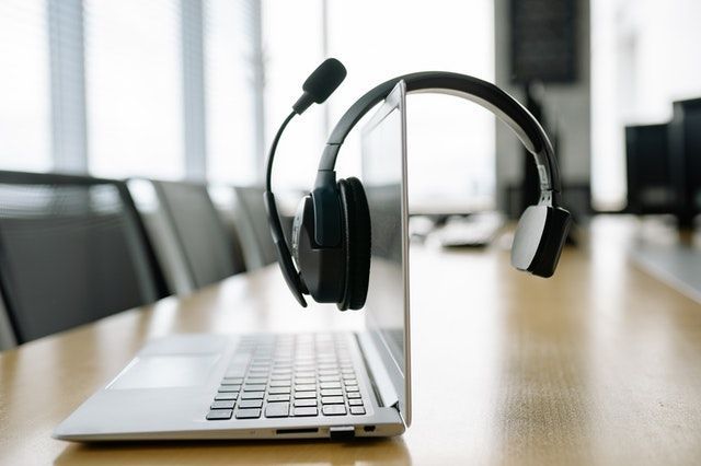 Outbound call center agent talking on headset and working on CRM system in a modern office environment